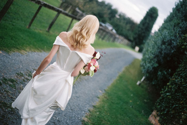 Bride walking a garden path, bouquet in hand, shot on 35mm film